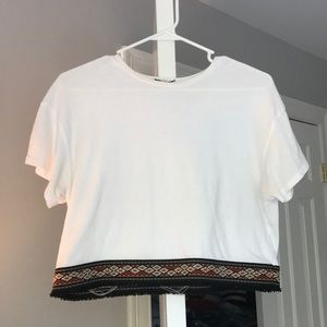White blouse/t shirt with embroidered bottom.
